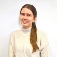 Headshot of Julia Cieslak in a cream jumper, standing in front of a white background.