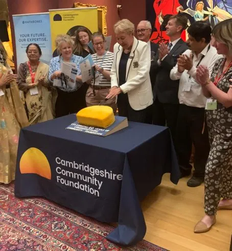 The Foundation's President cutting a celebration cake with the CEO, Chair of Trustees and supported charities and community groups.