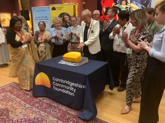 The Foundation's President cutting a celebration cake with the CEO, Chair of Trustees and supported charities and community groups.